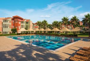 a pool at a resort with chairs and umbrellas at Megasaray Club Belek in Belek