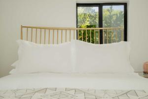 a white bedroom with a large bed and a window at Hillside Artist Retreat 3BR - Hills of Eagle Rock in Los Angeles