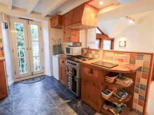 a kitchen with a stove and a microwave at Wood Cottage in Kendal