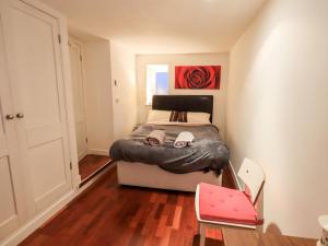 a small bedroom with a bed and a red painting at Wood Cottage in Kendal