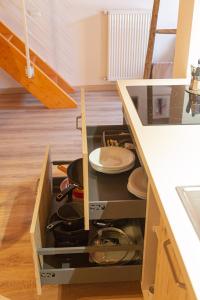a drawer in a kitchen with plates and pans at LE MUSE Comano Terme Holiday 2, primo piano in Comano Terme +37 photos