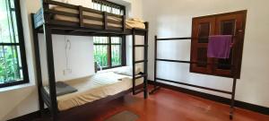 Zimmer mit 2 Etagenbetten und einer Tür in der Unterkunft Dutch Square Hostel in Alappuzha