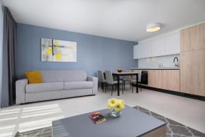 un soggiorno con un divano e un tavolo di Dolce Vista Suite Apartment Garden Palace Resort a Umag (Umago)