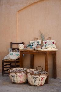 a table with baskets on it next to a wall at Tzila Bahariya in Bawati +97 photos