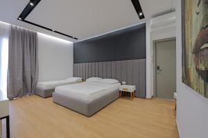 a bedroom with two beds and a large screen at Sea & Sand Hotel in Vlorë