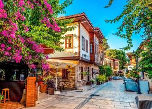 a cobblestone street in a town with pink flowers at Şehir Merkezinde Daire in Antalya
