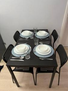 a black table with plates and utensils on it at Şehir Merkezinde Daire in Antalya