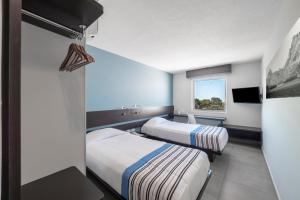 una camera d'albergo con due letti e una finestra di City Express Junior by Marriott Ciudad del Carmen a Ciudad del Carmen