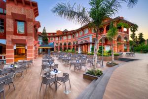 an outdoor patio with tables and chairs in front of a building at Megasaray Club Belek in Belek