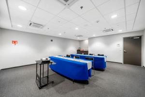 une salle de conférence avec des chaises bleues et une table dans l'établissement City Express Junior by Marriott Ciudad del Carmen, à Ciudad del Carmen