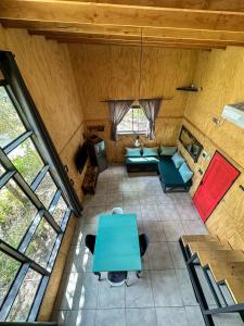 widok na salon z niebieskim stołem w obiekcie Molco Cabins Loft w mieście Pucón