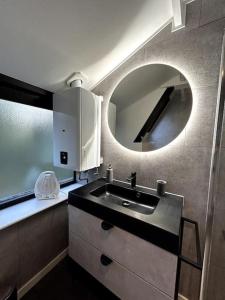 a bathroom with a sink and a mirror at Chaleureux chalet à Durbuy in Durbuy +30 photos