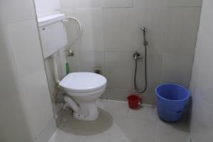a bathroom with a toilet and a blue bucket at Affordable and Cheapest stay in North Goa - 1BHK in Colovale