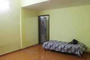 a bedroom with a bed in a room with a door at Affordable and Cheapest stay in North Goa - 1BHK in Colovale
