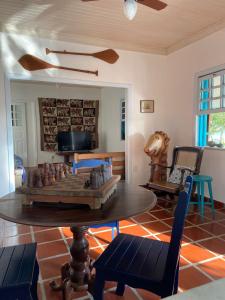 uma sala de estar com uma mesa e um sofá em Casa Dos Arcos Bed and Breakfast em Arraial do Cabo