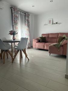 salon z różową kanapą, stołem i krzesłami w obiekcie Balcon San Rafael w Kordobie