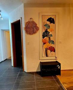 a room with a painting on the wall and a table at Appartement Les Salines in Roche +28 photos
