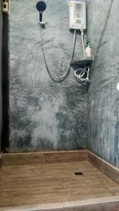 a bathroom with a shower with a hose on the wall at Ban Bang Home Resort in Haad Chao Samran