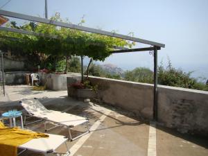 een patio met 2 stoelen en een tafel aan een muur bij Le Dimore di Chiara in Imperia