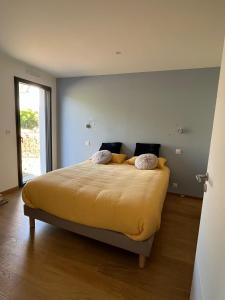 una camera da letto con un grande letto con lenzuola gialle di Glen Ross, plage à moins de 10 min à pied a Névez