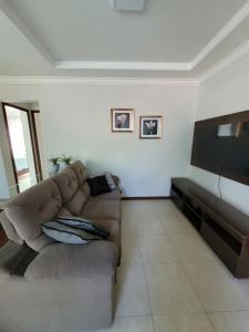 sala de estar con sofá y TV de pantalla plana en Apt. Praia dos Adventistas e 3 Praias, en Guarapari