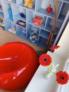 a red vase sitting on a table with flowers at Ihana kaksio Linnanmäen vieressä in Helsinki