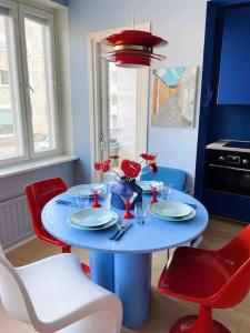 a blue table with red chairs and a blue table with flowers on it at Ihana kaksio Linnanmäen vieressä in Helsinki