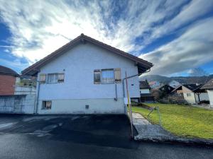 una casa blanca al lado de una calle en Blässchopfhüsli en Nesslau