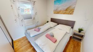 a bed in a room with two pillows at Haus MeerAuszeit - Erholung an der Nordsee in Schweiburg
