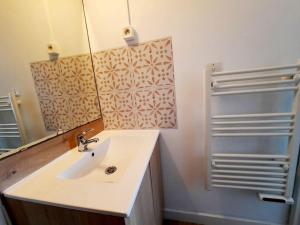 a bathroom with a sink and a mirror at Studio piscine proche plage et village naturiste in Cap d'Agde