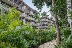 an apartment building with palm trees and a path at Tulum Paradise - Penthouse with Private Pool and Cenote in Tulum