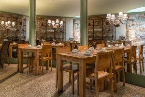 una sala da pranzo con tavoli e sedie in legno di Hôtel Prince de Conti a Parigi