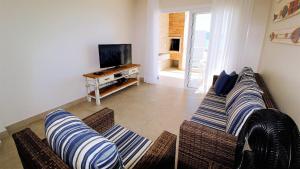 Sala de estar con 2 sofás y TV en 1079 - Apartamento com vista para o mar em Bombinhas, en Bombinhas
