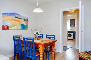 a dining room with a wooden table and blue chairs at Edinburgh Central 2-Bedroom Old Town Apartment in Edinburgh