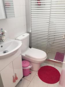 a white bathroom with a toilet and a sink at Sunrise view house in Molos Parou