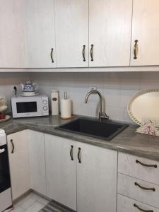 a kitchen with a sink and a microwave at Sunrise view house in Molos Parou +8 photos