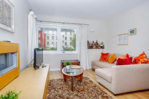 a living room with a couch and a tv at Edinburgh Central 2-Bedroom Old Town Apartment in Edinburgh
