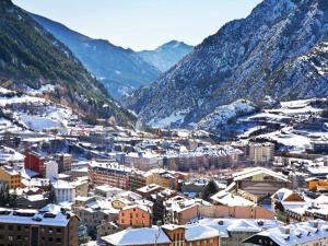 una ciudad cubierta de nieve con montañas en el fondo en Hotel Pere D'Urg 3000, en Encamp