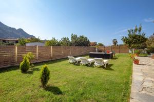 アギオス・ゴルディオスにあるVilla Mariettaの白い椅子と柵の並ぶ庭