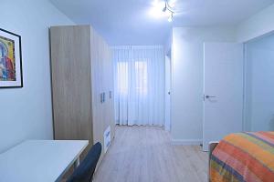 - une chambre blanche avec un lit et un placard dans l'établissement La casa de San Fernando, à Santander