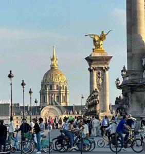 a group of people riding bikes in front of a building at Appartement Quartier Tour Eiffel in Paris