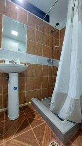 a bathroom with a sink and a shower with a shower curtain at Pieza independiente 2 camas con estacionamiento in Los Ángeles