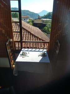 una mesa con un mantel blanco en el balcón en Casa com piscina e sauna em Petrópolis, en Petrópolis