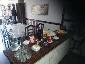 eine Küche mit einer Theke und einem Tisch mit Gläsern in der Unterkunft Casa com piscina e sauna em Petrópolis in Petrópolis