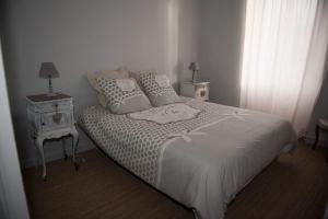 ein Schlafzimmer mit einem Bett mit einem Nachttisch und einem Bett sidx sidx sidx sidx sidx in der Unterkunft Bel appartement en pierre de 100 m2 avec cour. in Margaux