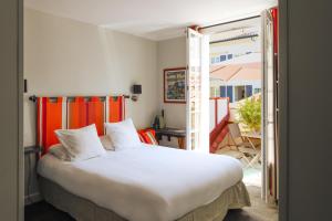 a bedroom with a large bed and a balcony at Boutique H&ocirc;tel Txoko in Saint-Jean-de-Luz