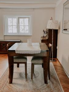 une table à manger avec deux chaises et une lampe dans l'établissement Vila Del Linz, à Ljubljana