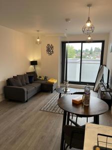 a living room with a couch and a table at Hemel Apartments- Tranquil Haven in Hemel Hempstead