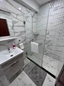 a bathroom with a glass shower and a sink at Kenitra Unique Design Appartment in Kenitra
