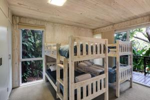two bunk beds in a room with windows at Billa Villa in Point Lookout